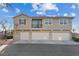 Townhome featuring a balcony and three garage doors, complemented by a landscaped yard at 4305 Morgan Manor St # 3, North Las Vegas, NV 89032