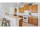 Well-lit kitchen with wood cabinets, white appliances and breakfast bar at 4305 Morgan Manor St # 3, North Las Vegas, NV 89032