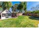 Backyard featuring a lush lawn, mature trees, and a charming playhouse near a fire pit at 4880 Hayride St, Las Vegas, NV 89149
