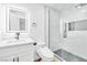 Modern bathroom features a vanity with a sleek mirror and a glass-enclosed shower with honeycomb tile at 4880 Hayride St, Las Vegas, NV 89149