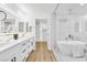 Bright bathroom featuring double sinks, sleek vanity, a glass enclosed shower, and access to a walk-in closet at 4880 Hayride St, Las Vegas, NV 89149