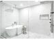 Bright and modern bathroom with a soaking tub, glass enclosed shower, and white marble-like walls at 4880 Hayride St, Las Vegas, NV 89149