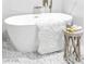 Bright bathroom with a freestanding bathtub and side table with decorative elements on an elegant mosaic floor at 4880 Hayride St, Las Vegas, NV 89149