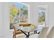 Bright breakfast nook with glass table and views of the well-manicured backyard at 4880 Hayride St, Las Vegas, NV 89149