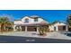 Charming two-story home with a three-car garage, lush landscaping, and a concrete driveway at 4880 Hayride St, Las Vegas, NV 89149
