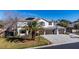 Welcoming two-story home featuring a three-car garage, a tile roof and verdant lawn with mature trees at 4880 Hayride St, Las Vegas, NV 89149