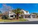 Inviting two-story home with a three-car garage, tile roof, and mature palm trees in the front yard at 4880 Hayride St, Las Vegas, NV 89149