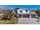 Welcoming two-story home featuring a three-car garage, solar panels, and a well-manicured lawn with palm trees at 4880 Hayride St, Las Vegas, NV 89149