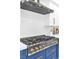 Close-up of a gas range with blue lower cabinets and white upper cabinets in a modern kitchen at 4880 Hayride St, Las Vegas, NV 89149