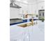 Modern kitchen with white and blue cabinets, a spacious island, and a gold sink and faucet at 4880 Hayride St, Las Vegas, NV 89149