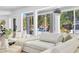 Bright living room featuring a white sofa, throw pillows, and large windows overlooking the pool at 4880 Hayride St, Las Vegas, NV 89149