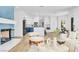 Open living space with stylish fireplace, white sofa, and kitchen with blue and white cabinetry at 4880 Hayride St, Las Vegas, NV 89149