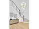 Staircase featuring a modern chandelier, sleek metal railings, and stylish wood console table at 4880 Hayride St, Las Vegas, NV 89149