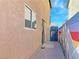 Side yard featuring a brick walkway, colorful mural, and blue access gate at 5288 Emelita St, Las Vegas, NV 89122