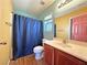 Cozy bathroom featuring a shower with blue curtain and a vanity with wood-finished cabinets at 5288 Emelita St, Las Vegas, NV 89122
