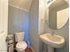 Cozy half bathroom featuring a pedestal sink and toilet with wood look floors at 5288 Emelita St, Las Vegas, NV 89122