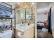 Updated bathroom features a dual mirror, decorative wallpaper, and ceramic white sink at 53 Montello Ave, Las Vegas, NV 89110
