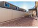 View of a fully fenced backyard with rock landscaping and covered patio, offering privacy and an area for relaxation at 617 Abrazar Ave, North Las Vegas, NV 89081