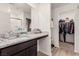 Modern bathroom with granite countertops, a sink, a mirror and a walk in closet at 617 Abrazar Ave, North Las Vegas, NV 89081