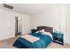 Bright bedroom with a queen bed, blue nightstands, and neutral decor, creating a calming atmosphere at 617 Abrazar Ave, North Las Vegas, NV 89081
