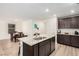 Stylish kitchen featuring a central island, granite countertops, dark cabinetry, and modern appliances at 617 Abrazar Ave, North Las Vegas, NV 89081