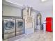 Garage laundry area boasts front load machines, shelving, and red mini-fridge for added convenience at 6925 Emerald Springs Ln, Las Vegas, NV 89113