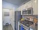 Modern kitchen featuring stainless steel appliances, dark countertops, and laundry access at 7111 S Durango Dr # 305, Las Vegas, NV 89113