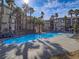 Resort-style community pool surrounded by palm trees, sun loungers, and inviting blue water at 7111 S Durango Dr # 305, Las Vegas, NV 89113