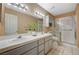 Bathroom with double sink vanity, large mirror and tiled shower with glass door at 8452 Boseck Dr # 110, Las Vegas, NV 89145