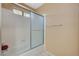 Bathroom featuring a shower-tub combo with glass doors and tiled walls at 8452 Boseck Dr # 110, Las Vegas, NV 89145