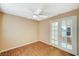 Bright bedroom features wood-look floors, ceiling fan, and glass paneled doors to another room at 8452 Boseck Dr # 110, Las Vegas, NV 89145