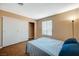 Bedroom with wood floors, closet with sliding doors, and a large window at 8452 Boseck Dr # 110, Las Vegas, NV 89145