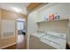 Convenient laundry area with washer, dryer, and shelving for storage at 8452 Boseck Dr # 110, Las Vegas, NV 89145