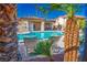 Relaxing community pool featuring lounge chairs and umbrellas, surrounded by palm trees and tropical foliage at 8501 W University Ave # 2020, Las Vegas, NV 89147