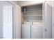Dedicated laundry closet with a washer, dryer, and shelving for storage at 8501 W University Ave # 2020, Las Vegas, NV 89147