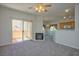 Spacious living room with modern gray carpet, fireplace, and sliding glass doors to patio at 8501 W University Ave # 2020, Las Vegas, NV 89147