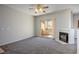 Bright living room featuring carpet, fireplace, and access to outdoor patio at 8501 W University Ave # 2020, Las Vegas, NV 89147