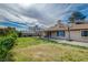 Large grassy backyard featuring a covered patio, basketball hoop, and mature landscaping at 872 Linn Ln, Las Vegas, NV 89110