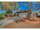 Inviting single-Gathering home boasts a two-car garage, mature trees, and a well-maintained front yard at 872 Linn Ln, Las Vegas, NV 89110