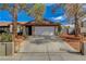 Home with a two-car garage, mature trees, and concrete driveway at 872 Linn Ln, Las Vegas, NV 89110