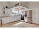 Bright kitchen features white cabinets, stainless appliances, and tile flooring at 872 Linn Ln, Las Vegas, NV 89110
