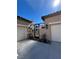 A wrought iron courtyard entrance between two garages with desert plants and accent lighting at 9361 Olympia Falls Ave, Las Vegas, NV 89149