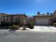 Attractive single-Gathering home boasting desert landscaping, two garages, and a stone facade at 9361 Olympia Falls Ave, Las Vegas, NV 89149