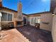 Stamped-concrete patio with outdoor fireplace, string lights, and french doors at 9361 Olympia Falls Ave, Las Vegas, NV 89149