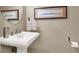 Charming half bathroom featuring a pedestal sink, decorative mirror, and wall art at 10556 Nantucket Ridge Ave, Las Vegas, NV 89166