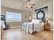 Comfortable bedroom with light-colored walls, ceiling fan, light hardwood floors, and outdoor views at 10556 Nantucket Ridge Ave, Las Vegas, NV 89166