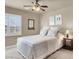 Cozy bedroom featuring a comfy bed, window with shutters, and a stylish ceiling fan at 10556 Nantucket Ridge Ave, Las Vegas, NV 89166