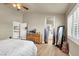 Bright bedroom featuring light-colored walls, ceiling fan, light hardwood floors, and natural light at 10556 Nantucket Ridge Ave, Las Vegas, NV 89166