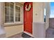 Close-up of a bright red front door with a decorative wreath and sidelight window at 10556 Nantucket Ridge Ave, Las Vegas, NV 89166