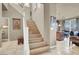 Open-concept staircase featuring wood stairs, white railings, and easy access to the kitchen at 10556 Nantucket Ridge Ave, Las Vegas, NV 89166